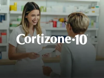 A pharmacist and a middle-aged woman talking in a pharmacy alley about Cortizone-10.